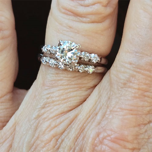 Restored diamond engagement ring and wedding band worn on a hand